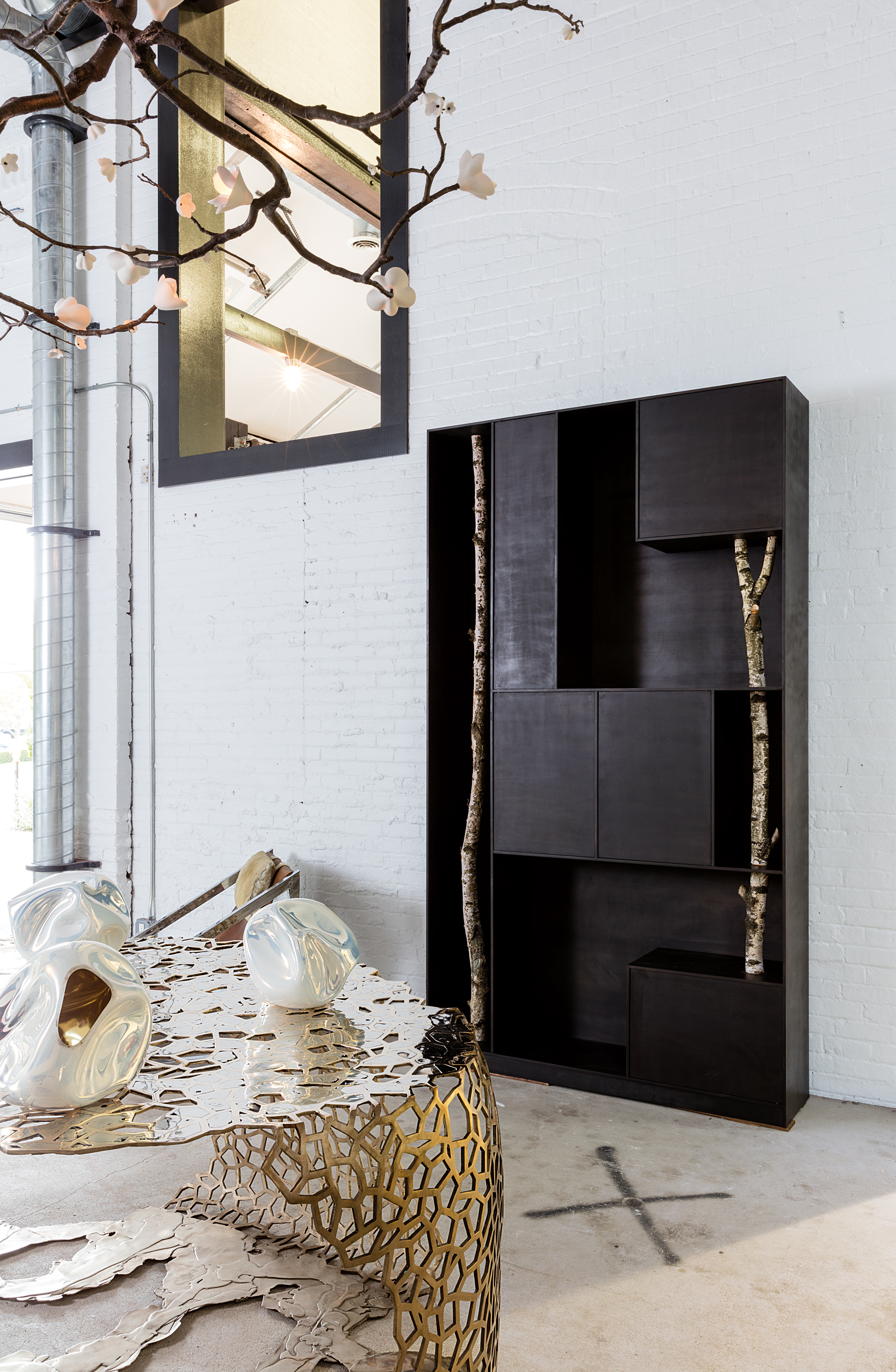 A cabinet by the Italian architect Andrea Branzi is next to a 2015 lace-like bronze table by the American designer David Wiseman.
