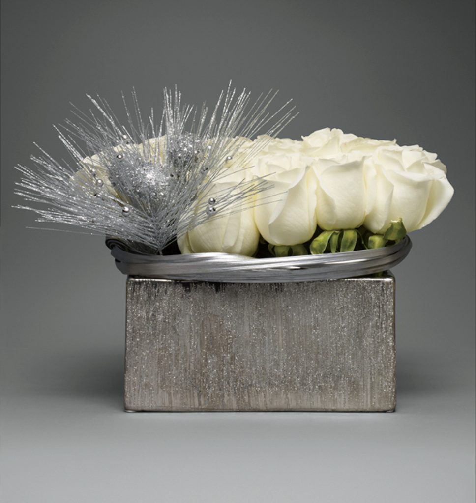 White Tibet roses, silver berries, and silver lily grass are set in a square silver container