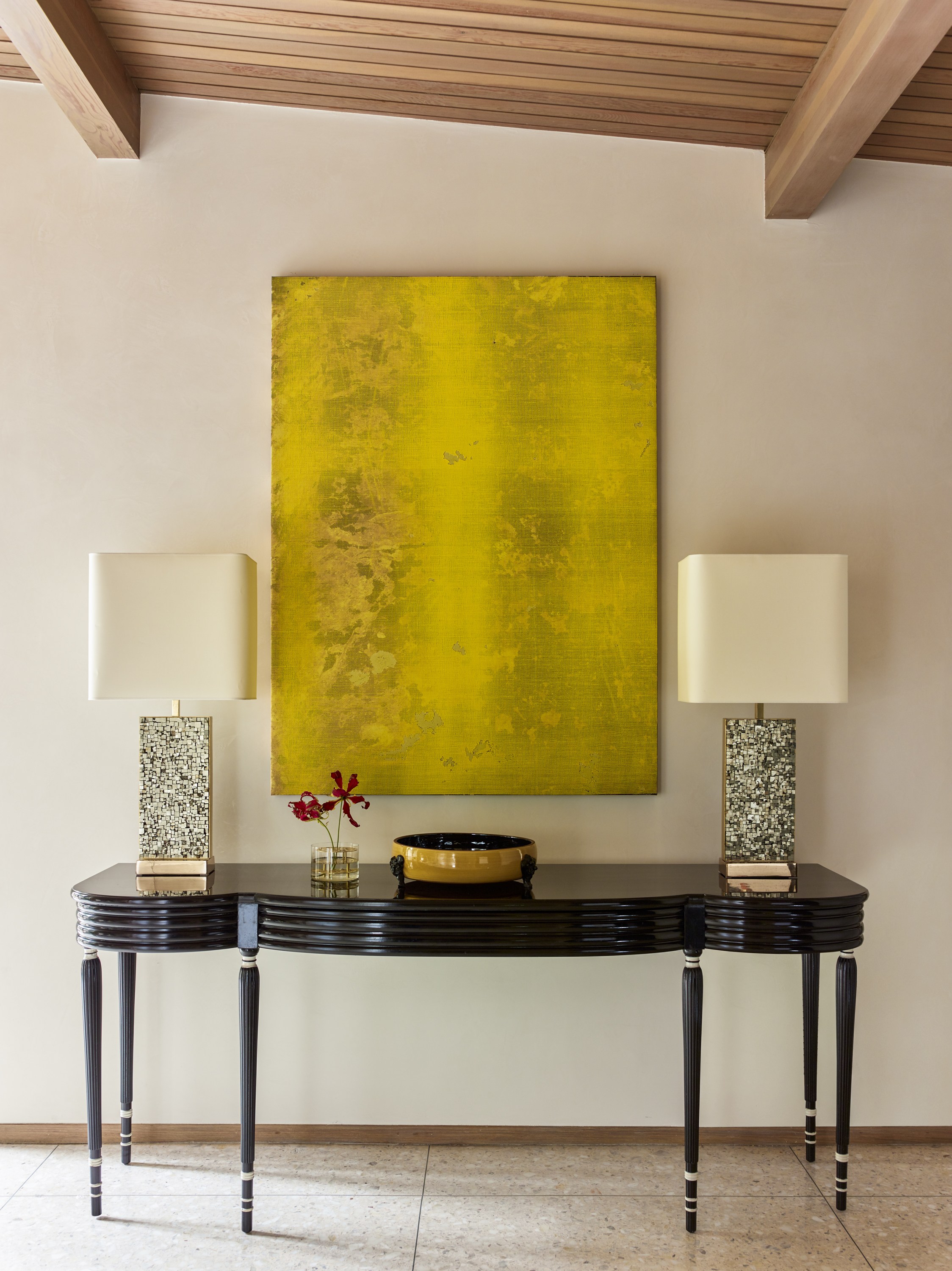 In the entryway, a console Jean Dunand is paired with brass-and-pyrite lamps by Georges Mathias and an Evan Nesbit artwork. 