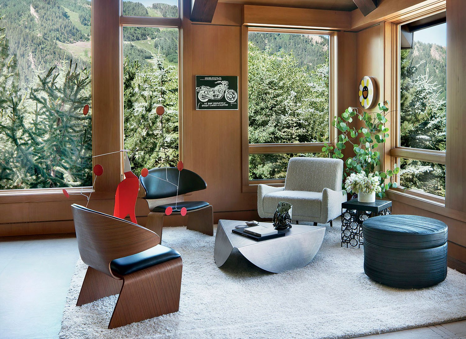 Hanging in a corner of the living room are small works by Andy Warhol and Takashi Murakami, while the Alexander Calder sculpture is perched between vintage Hans Olsen chairs. Joining them are a Xandre Kriel cocktail table, a Jorge Zalszupin armchair from Espasso, and a side table by Christophe Côme; the rug is by Beauvais Carpets.